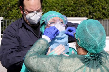 İtalyan hemşireler kendilerini koruyucu giysi, koruyucu maskeler ve eldivenlerle Puglia, İtalya 'da olası bir Coronavirus covid-19 vakası için evde örnek almak üzere hazırlıyorlar - 24 / 04 / 2020