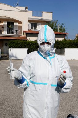 İtalyan hemşireler kendilerini koruyucu giysi, koruyucu maskeler ve eldivenlerle Puglia, İtalya 'da olası bir Coronavirus covid-19 vakası için evde örnek almak üzere hazırlıyorlar - 24 / 04 / 2020