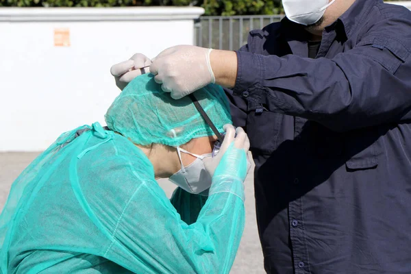 İtalyan hemşireler kendilerini koruyucu giysi, koruyucu maskeler ve eldivenlerle Puglia, İtalya 'da olası bir Coronavirus covid-19 vakası için evde örnek almak üzere hazırlıyorlar - 24 / 04 / 2020