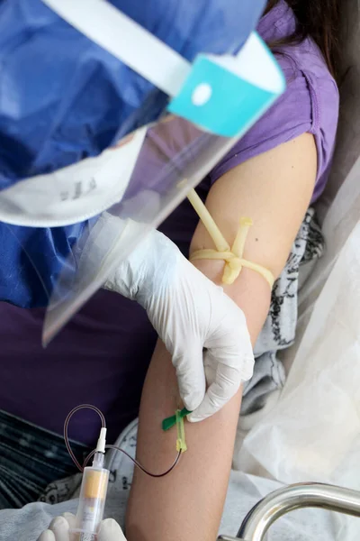 Hemşire olası bir Coronavirus covid-19 vakası nedeniyle kan testi için bir hastadan kan örneği alıyor.