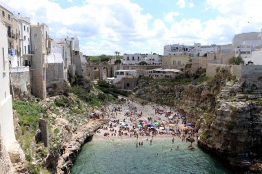 Polignano a Mare, Puglia, İtalya 'daki ünlü Lama Monachile plajında hamamlar ve turistler