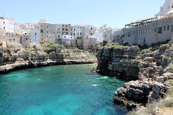 Polignano a Mare, Puglia, İtalya 'daki ünlü Lama Monachile plajında hamamlar ve turistler