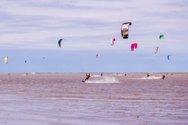Uçurtma atlayan çeşitli insanlar.