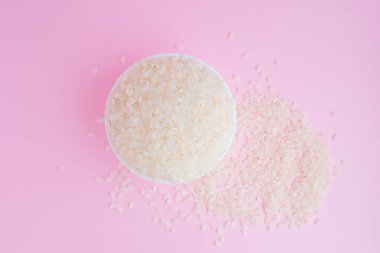 Pembe arka planda pişmemiş pirinç inliyor.