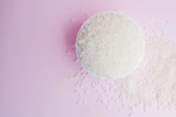 Semole di riso crude su fondo rosa — Foto Stock