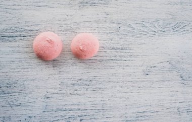 Hafif ahşap arka planda pembe şekerlemeler.