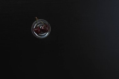 Koyu arkaplanda bir yığın suyun içindeki kirazlar.