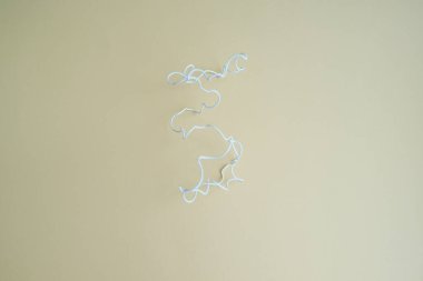 Açık sarı arkaplanda beyaz kıvrımlı kablo