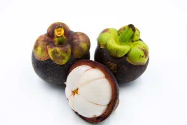 Beyaz bir zemine yerleştirilmiş üç mangosteen..