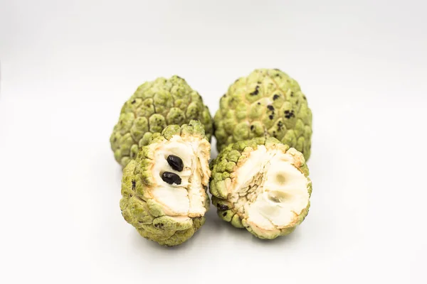 Four custard apples placed on a white ground.