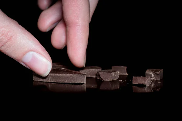 Close Mão Feminina Leva Pedaços Chocolate Amargo Preto Isolado Fundo — Fotografia de Stock