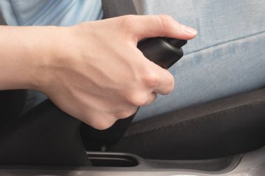 Kadın el freni düğmesine basar, acil durum duruşu, park yeri, aşağı yuvarlanma tehlikesi. Yakın çekim, seçici odaklanma.