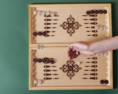 Bir el tavla tahtasının üzerine beyaz bir kemik atar. Zafer konsepti.