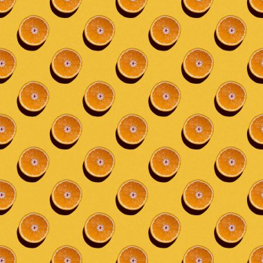 Sarı arka planda, portakalların renksiz desenleri. Üst görünüm.