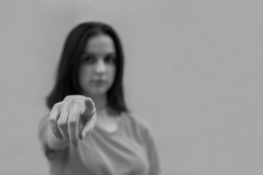 Gülümseyen kız işaret parmağıyla dokunmatik ekran arayüzü kullanıyor, siyah ve beyaz, seçici odak