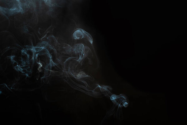 Figured smoke on a dark background. Abstract background, design element, for overlay on pictures.