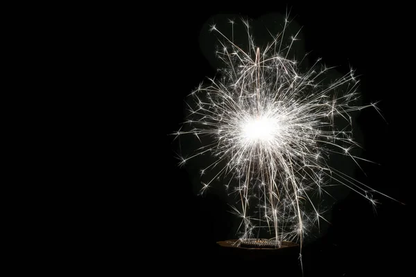 해피 뉴 이 얼, 축제, 반짝이는 하얀 불꽃 반짝 이는 스파클러 또는 검은 배경에 대한 경례. 휴일 컨셉, 복사 공간. — 스톡 사진