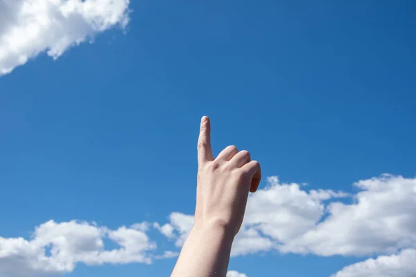 Крупный План Женской Руки Указательным Пальцем Фоне Голубого Неба Облаками — стоковое фото