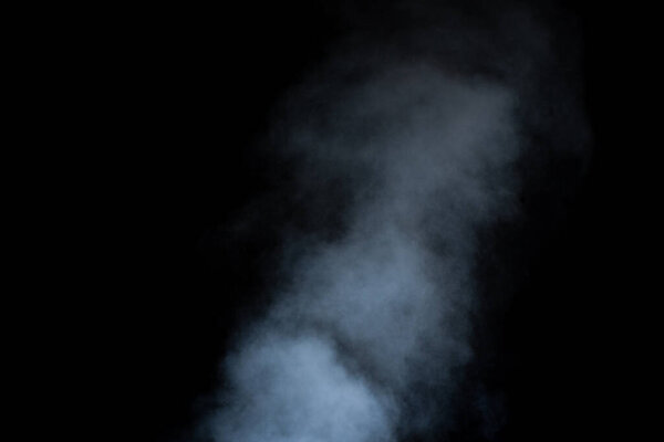 Close-up curls of steam or smoke with drops of moisture isolated on black background, low key, copy space. Clear simple template for design