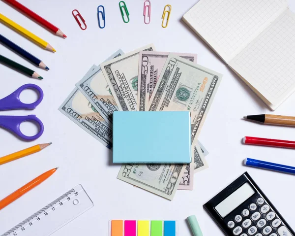 Foto de vista superior de dólares para ir de compras en el centro y papelería de colores, aislado en blanco con espacio de copia — Foto de Stock