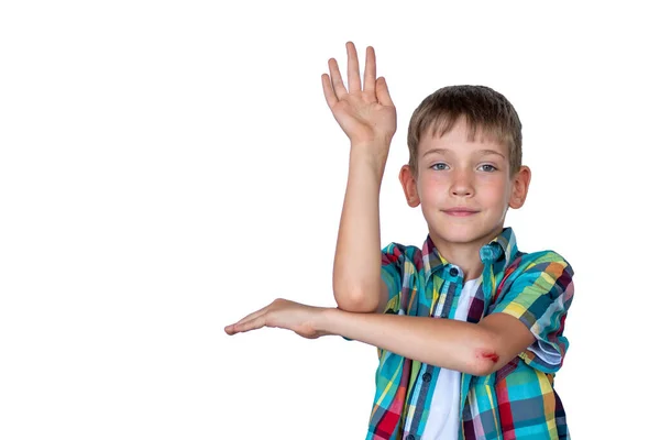 Un chico listo y lindo levanta la mano para responder en clase. Niño feliz contra pizarra blanca. Concepto de educación, vuelta a la escuela — Foto de Stock