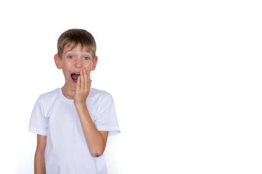 Beyaz tişörtlü, beyaz arka planda izole edilmiş sarışın çocuk. Mutlu çocuk beyaz tahtaya karşı