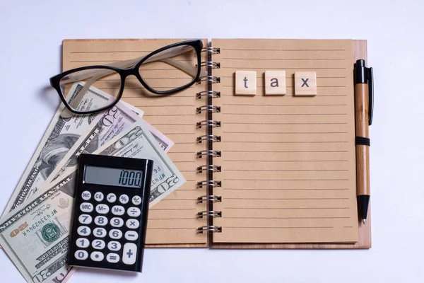 Концепція бізнесу, вид зверху, калькулятор, ручка, окуляри, блокнот, написаний з податком на білому тлі — стокове фото
