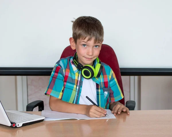 Chico Lindo Está Sentado Una Mesa Mirando Portátil Escribiendo Tareas — Foto de Stock