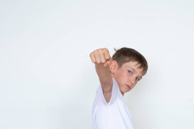 Yumruk yumruğa. Beyaz arka planda uzanan beyaz tişörtlü bir çocuk. Hedefe ulaşmanın önündeki engelleri aşmak. Kazanan konsept. Boşluğu kopyala