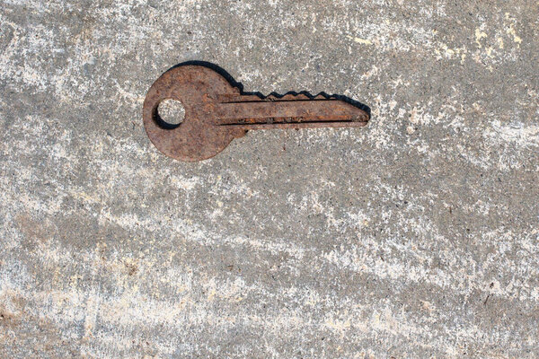One old rusty key on a gray background. Stay at home concept. Abandoned, forgotten concept.