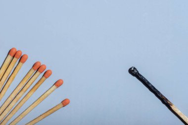 Bir tarafta turuncu başlı kibrit, diğer tarafta da yanık kibrit vardı. Kopya uzayı. İş konsepti