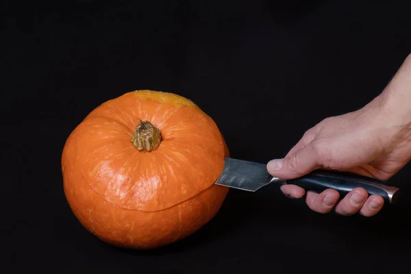 Mano Tiene Coltello Taglia Una Zucca Arancione Rotonda Isolata Sfondo — Foto Stock