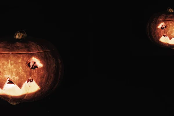 Diverse zucche sorridenti di Halloween con occhi luminosi isolati su sfondo nero. Può usare per la cartolina, elemento di design — Foto Stock