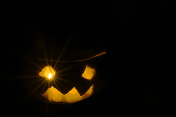 万圣节南瓜的微笑和可怕的眼睛为一个聚会 杰克灯笼孤立在黑色的背景 亮晶晶的南瓜灯的眼睛 可作为明信片使用 — 图库照片