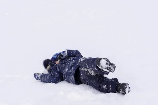 Ein Junge Winterblauer Kleidung Liegt Auf Dem Weißen Schnee Outdoor — Stockfoto