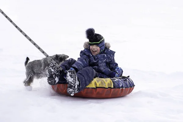 Ein Junge Winterkleidung Fährt Auf Einem Aufblasbaren Schlitten Auf Dem — Stockfoto