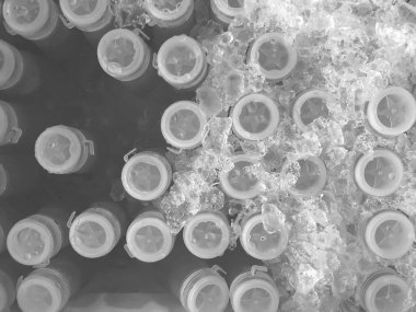 Siyah ve beyaz resim, siyah ve beyaz bir görüntü oluşturma fikri, buzda donmuş taze meyve suyu içeren plastik bir şişenin üst görüntüsü..