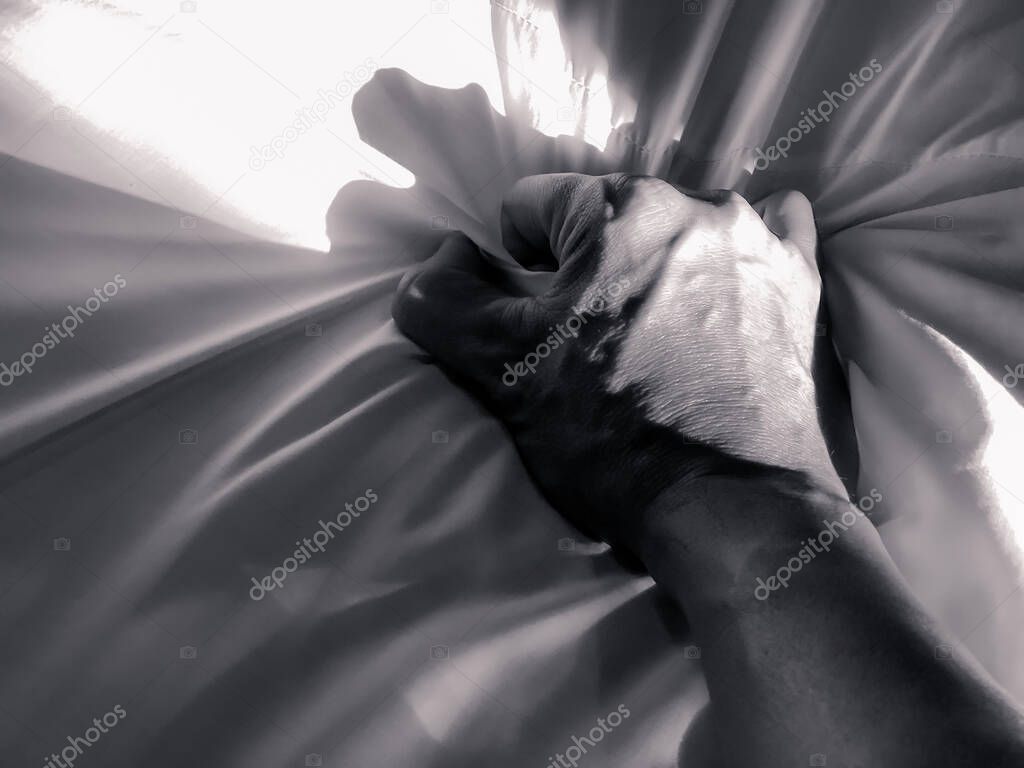 Black and white image concept, The man's hand pulled the white sheets, Hand mauled the white sheets on the bed, hands of a doctor with patient in the hospital, doctor with patient