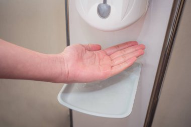 Coronavirus Covid-19 Önleme Konsepti. Umumi bir tuvalette sıvı sabunla el yıkamak..