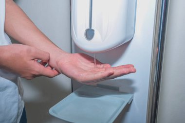 Coronavirus Covid-19 Önleme Konsepti. Umumi bir tuvalette sıvı sabunla el yıkamak..