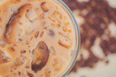 Ahşap bir masada buzlu kahve, kuru kahve çekirdekli buzlu kahve..