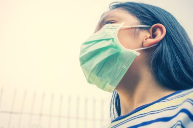 Coronavirus Covid-19 virüsü ve hava kirliliği pm2.5 konsepti, onu Corona virüsünden koruyacak maskeli kız. Corona virüsü salgını.