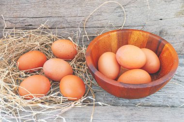 Çiftlikten taze tavuk yumurtaları ahşap bir kaba konur ve sonra ahşap zemine konur..