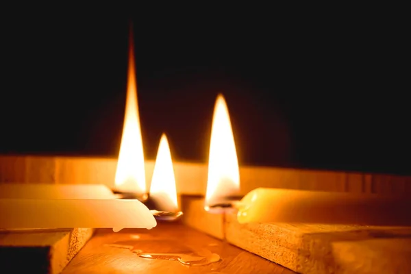 White Candles Burning in the Dark with lights glow, The burning candle\'s flame in the dark background,  a symbol of the Christian faith, Candles Burning in the Dark with lights glow.