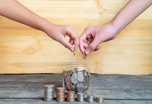 Pomóż Zaoszczędzić Pieniądze Przyszłość Obie Ręce Upuszczają Monetę Szklanki Oszczędnościowej — Zdjęcie stockowe