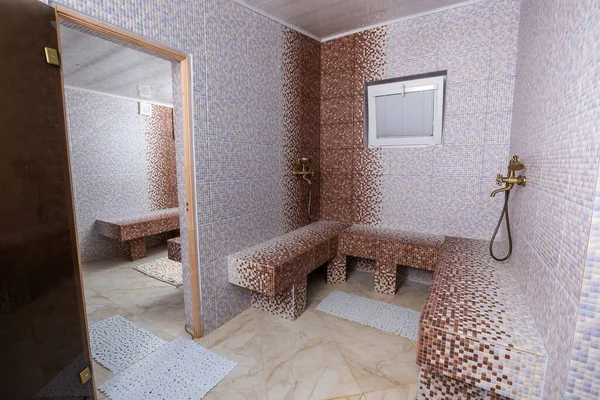 Hamam, traditional turkish sauna. Classic hammam interior design. Mosaic walls and benches.