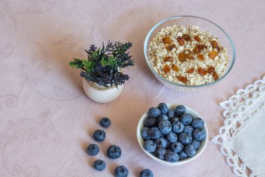 Bir kase granola, kuru üzüm ve yabanmersini. Her gün sağlıklı bir kahvaltı. Uzayı kopyala Bej keten arka plan. Düz yatıyordu