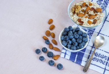 Bir kase granola, kuru üzüm, fındık ve yabanmersini. Her gün sağlıklı bir kahvaltı. Uzayı kopyala Bej keten arka plan. Düz yatıyordu