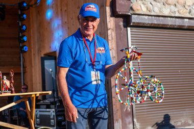 Minsk, Belarus, 11.06.2016. Eskisi gibi. Mavi tişörtlü adam dekoratif bisikleti tutuyor. Miting katılımcılarını tebrik ederim. Yakın plan portre. Açık hava görünümü.