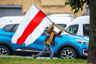Minsk, Belarus, 23.08.2020. Halk cumhurbaşkanlığı seçimlerinden sonra ve Alexander Lukashenko rejimine karşı protestolar düzenliyor. Bayrakları elimizde tutuyoruz.